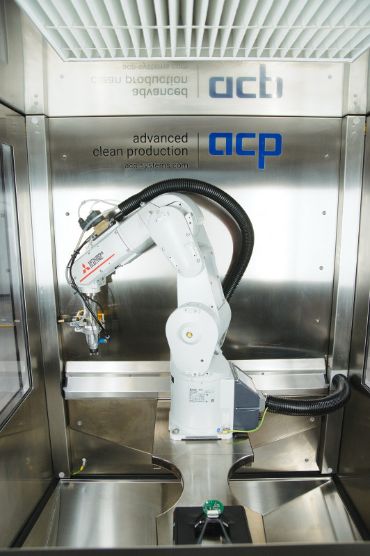 Das komplett aus Edelstahl gefertigte Reinigungssystems mit glatten Oberflächen ist mit einem Roboter ausgestattet. Es lässt sich einfach in verkettete Fertigungslinien integrieren und digital steuern. - © acp systems AG