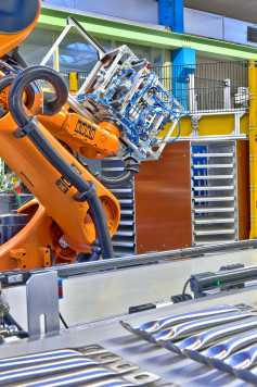 Aus dem Rundtaktmagazin werden die Trays in eine Greiferkammer  zum ersten Roboter geschoben, geklemmt gewendet und auf Bänder abgelegt. / © DALEX Schweißmaschinen GmbH & CO. KG