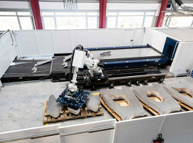 Ein Roboter sortiert die geschnittenen Bauteile von der Laserblanking-Anlage von TRUMPF ab.