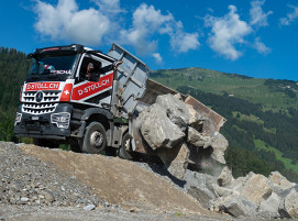 Lkw mit einem „Rockbox“-Aufbau von Moser beim Entladen von Felsblöcken in den Schweizer Bergen. Die Rockbox basiert auf einer modernen Schweißverbundkonstruktion, die hohe Ansprüche an Leichtigkeit und Festigkeit miteinander vereint.