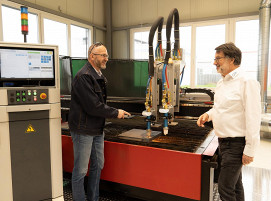 Im Show-Room der IHT Automation in Baden-Baden präsentieren Geschäftsführer Kurt Nachbargauer (rechts) und Martin Roubicek (Sales and Marketing Manager) eine Schneidmaschine mit E°CUT HMI und integrierter APC-Browserkachel. Das APC-System ist auf der Maschine montiert.