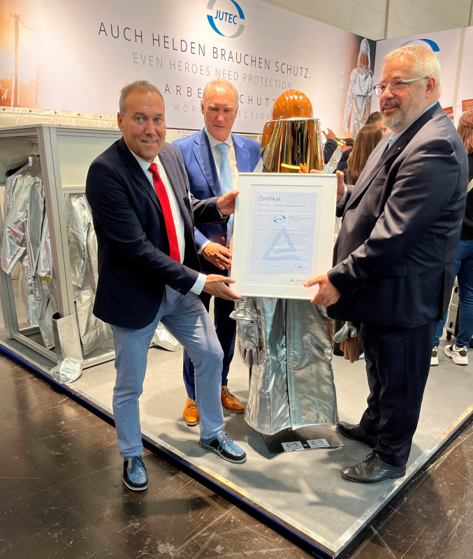(from left to right) Stephan Muscheites, Sales Director, and Stefan Jung, Managing Director of JUTEC GmbH, receiving the Heat Protection compact // Hitzeschutz kompakt certificate from Olaf Seiche, Regional Business Field Manager and Registered Manager of TÜV Rheinland Cert GmbH, at the A+A trade fair in Düsseldorf. - © JUTEC