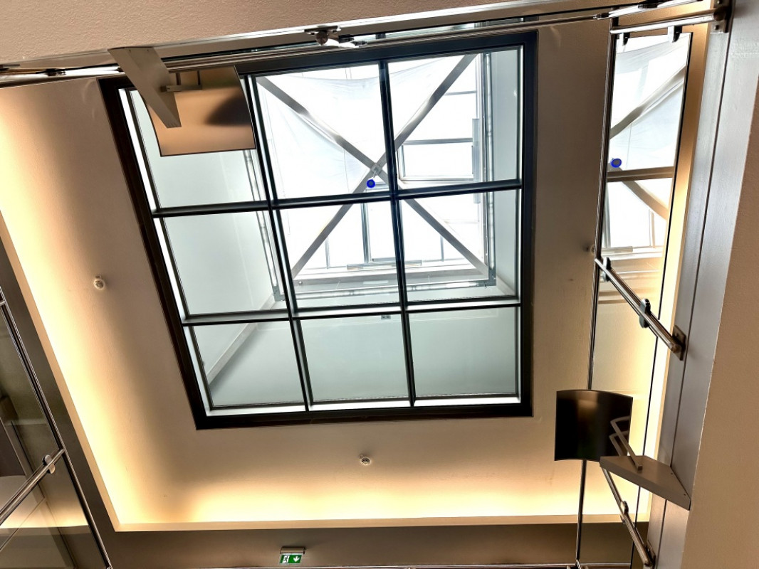 Die neue Stahlunterkonstruktion mit ihren neun Feldern für die Glasscheiben bringt viel Licht ins Gebäudeinnere und erhellt auch die tiefer liegenden Büro- und Besprechungsräume. - © M&T