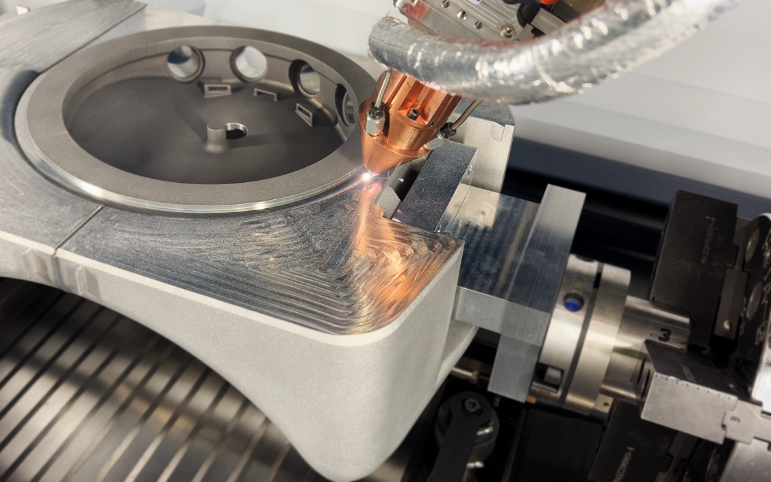 Beim LMD-Verfahren schmilzt ein Laserstrahl die Oberfläche, während Metallpulver zugeführt wird. - © toolcraft AG