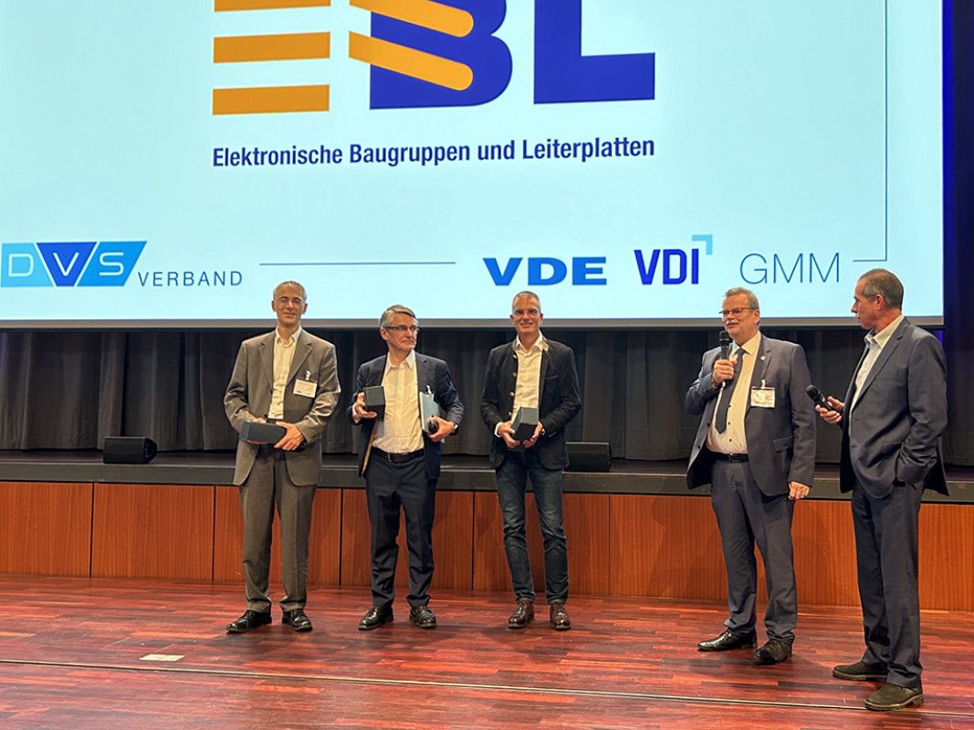 : Impression von der Fachtagung 2024: (v. l. n. r.) Keynote-Sprecher des Vorjahres Dr.-Ing. Nils Nissen (Fraunhofer IZM), Prof. Dr. Clemens  Cap (Universität Rostock) und Dr.-Ing. Michael Tagscherer (Giesecke + Devrient) sowie Prof. Dr.-Ing. Mathias Nowottnick (wissenschaftlicher Tagungsleiter), Bernd Enser (Vorsitzender der  Programmkommission der EBL) - © Doris Jetter