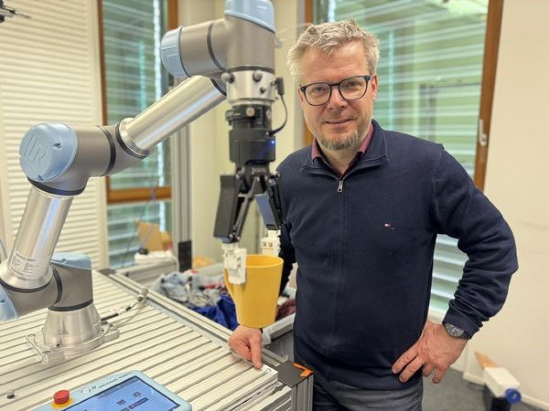 Hubert Zangl (Institut für Intelligente Systemtechnologien) mit dem Robotergreifer - © aau/Müller