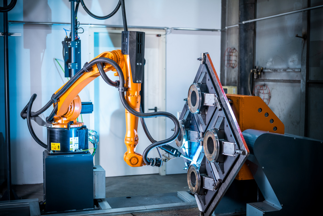 Schweißen auf dem Dreh-Kipp-Tisch. Vorne links befindet sich das verschiebbare Gegenlager, darüber der Autogenbrenner in Parkposition - © EWM GmbH