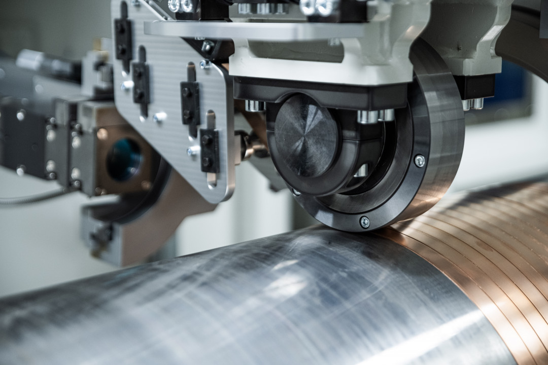 Fraunhofer IWS has developed the new "laser direct plating" process, which creates a functional layer directly on the base component by winding a strip-shaped metal spirally onto rotationally symmetric parts and bonding it locally to the substrate using laser energy. - © Christoph Wilsnack/Fraunhofer IWS