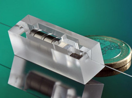 Das im BMFTR-Förderprojekt HiPEQ entwickelte, im SLE-(Selektives Laser-induziertes Ätzen)-Prozess gefertigte Packaging-Modul integriert Optiken, Isolator und Strahlteiler auf engstem Bauraum und unterstützt deren µm-genaue Ausrichtung.