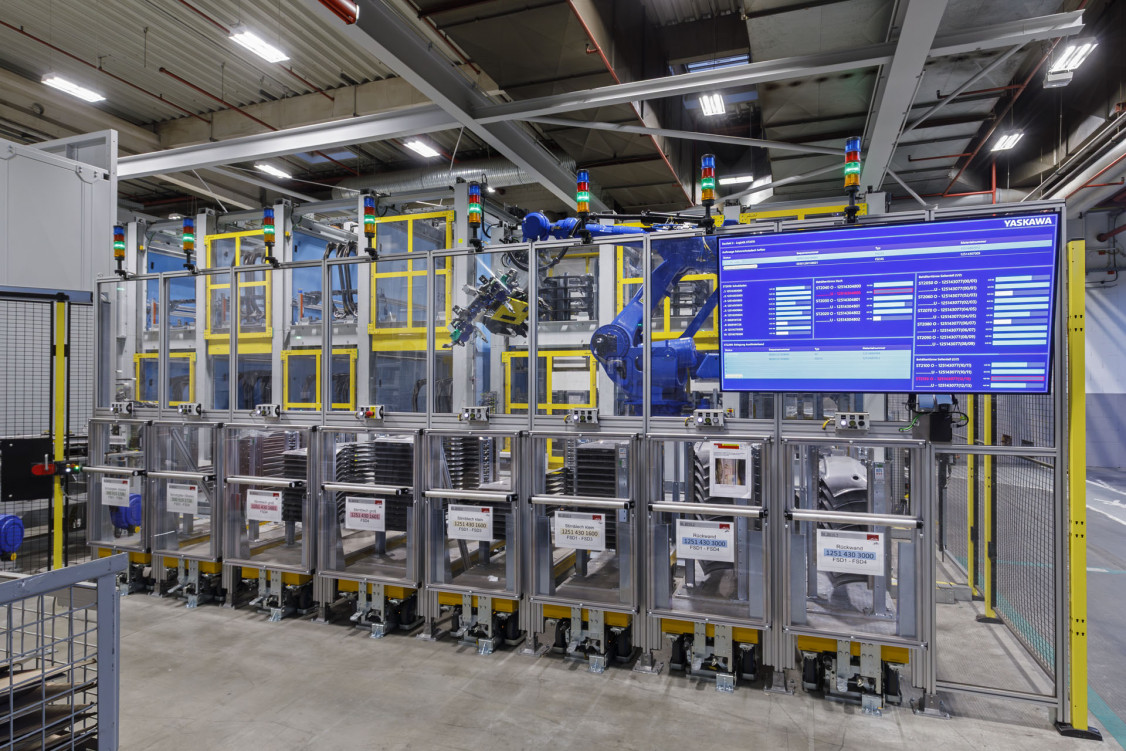 Blick auf das Baufeld mit den Schweißstationen – und auf die vom Yaskawa Production  System (YPS) erzeugte Visualisierung. - © Yaskawa Europe GmbH
