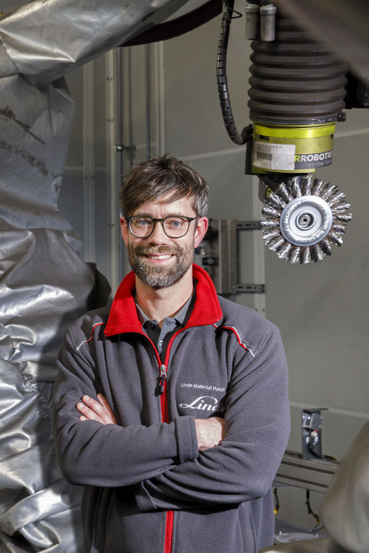 Christopher Taupp, Project Manager Industrialization Projects bei Linde MH, an der  robotergestützten Verputzstation. - © Yaskawa Europe GmbH