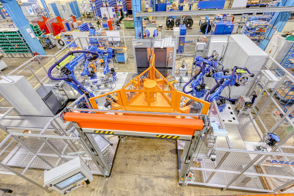 Für einen namhaften Automobilhersteller konzipierte und fertigte DALEX mehrere Roboterschweißanlagen zum Schweißen von Abgasstrangisolierungen. Ein wichtiger Bestandteil der Anlagen, um den Produktionsablauf komplett zu automatisieren, ist die gemeinsam mit KYOKUTOH entwickelte vollautomatische Nacharbeitungseinheit. - © DALEX Schweißmaschinen GmbH & Co. KG