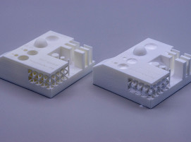 Zwei Testbauteile aus PA12, die mittels Selektivem Lasersintern hergestellt wurden: links nach der Bestrahlung mit Kunststoffgranulat, rechts ohne Strahlbehandlung.